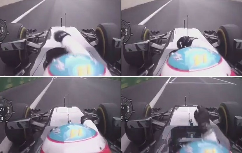 Alonso desabrochandose el cinturón de seguridad y saliendo un poco del cockpit para apretar el botón de Neutral